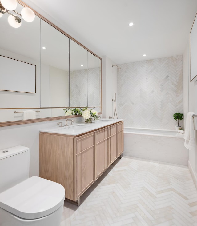 bathroom with toilet, recessed lighting, double vanity, and a sink