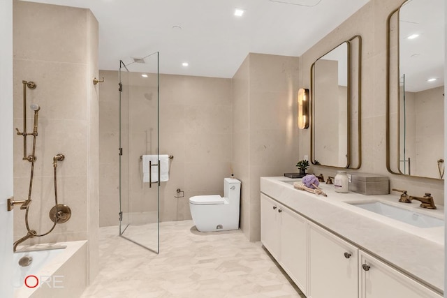 bathroom featuring tile walls, vanity, a shower with door, and toilet