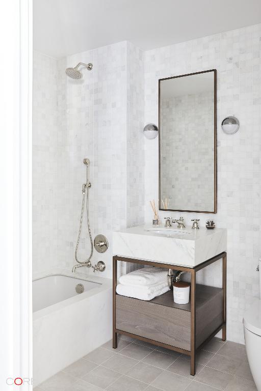 bathroom with tile walls, tile patterned flooring, tiled shower / bath combo, and toilet