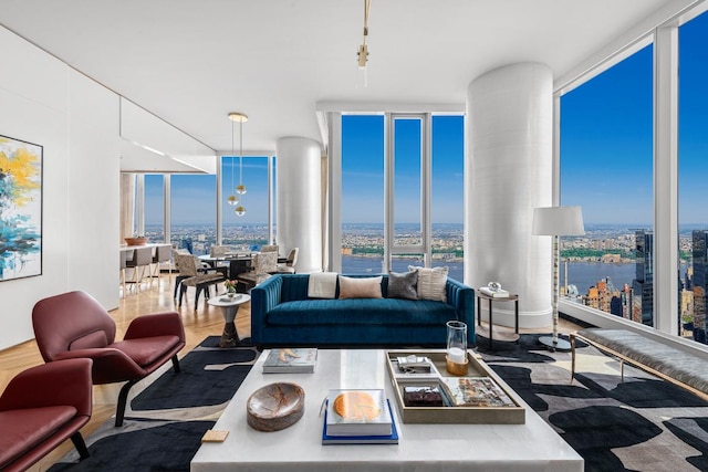 living room featuring expansive windows, a water view, and hardwood / wood-style flooring