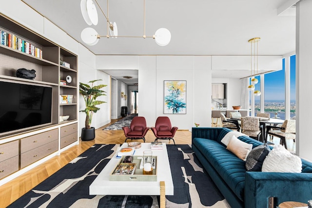 living room featuring a chandelier and light parquet flooring