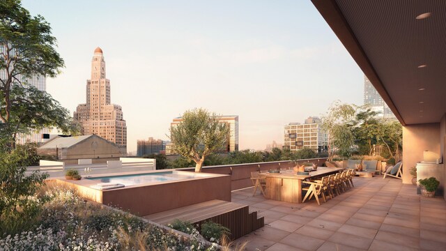 patio terrace at dusk featuring outdoor dining area and a city view