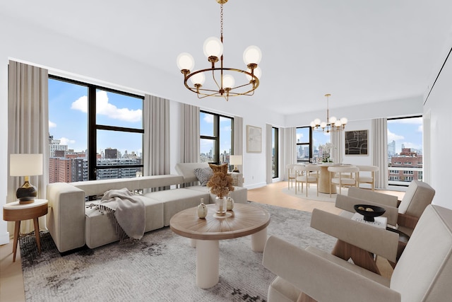 living room featuring a city view, light wood-style flooring, and an inviting chandelier