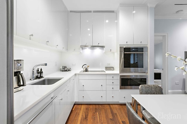 kitchen with sink, white cabinetry, double oven, dark hardwood / wood-style floors, and black electric cooktop