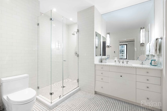 bathroom featuring vanity, tile walls, toilet, and walk in shower