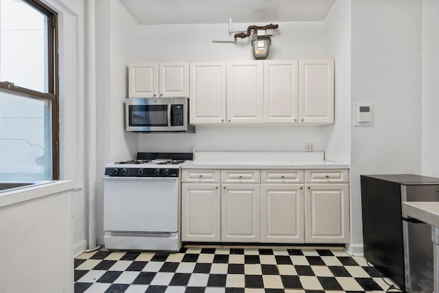 kitchen with white cabinetry and white range with gas stovetop