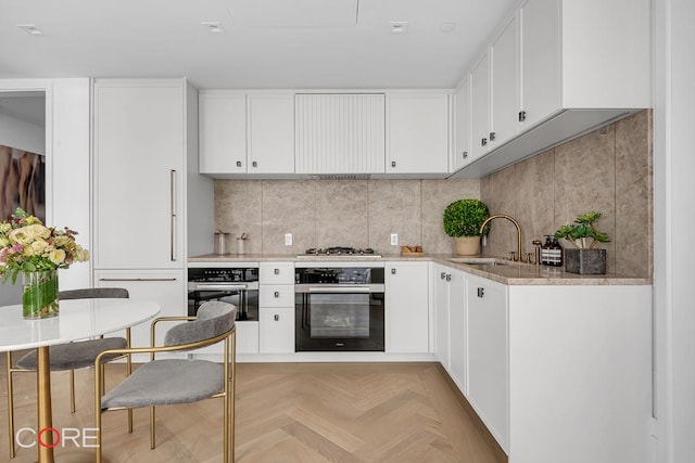 kitchen with oven, sink, and white cabinets