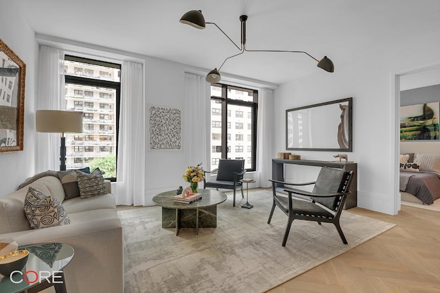 sitting room with plenty of natural light, a chandelier, and light parquet flooring