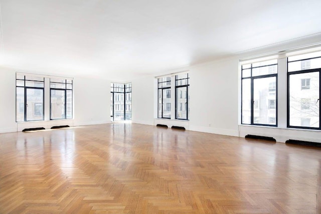 unfurnished room with plenty of natural light and light parquet floors