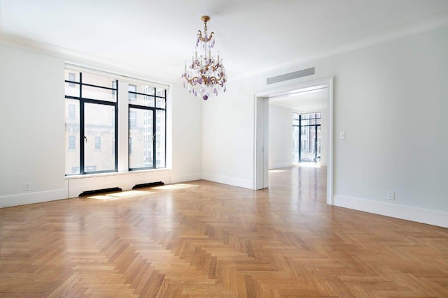 spare room with a notable chandelier, crown molding, plenty of natural light, and light parquet flooring