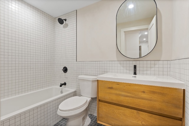 full bathroom featuring tile walls, tile patterned flooring, vanity, tiled shower / bath, and toilet