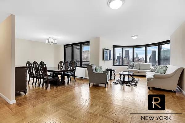 living room featuring light parquet flooring, a healthy amount of sunlight, and a chandelier