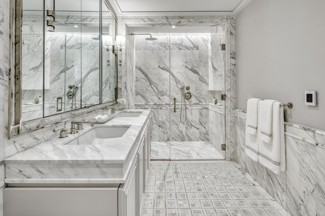 bathroom featuring a marble finish shower, tile walls, crown molding, and a sink