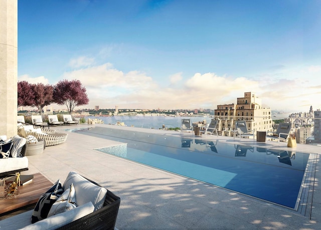 view of pool featuring a view of city, a patio area, and a water view