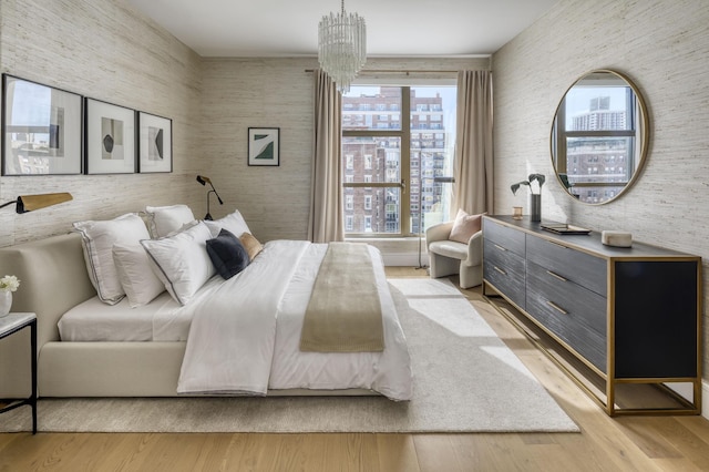 bedroom with a chandelier and wood finished floors