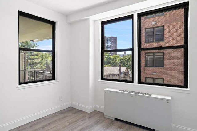 spare room with radiator and light hardwood / wood-style floors