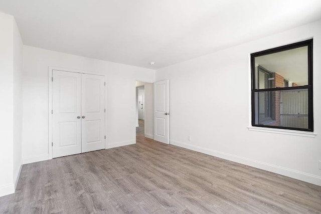 unfurnished bedroom with light hardwood / wood-style floors and a closet