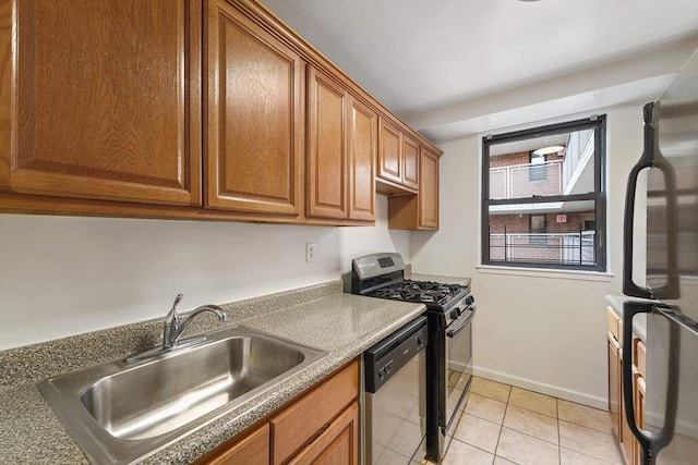 kitchen with sink, light tile patterned floors, and appliances with stainless steel finishes