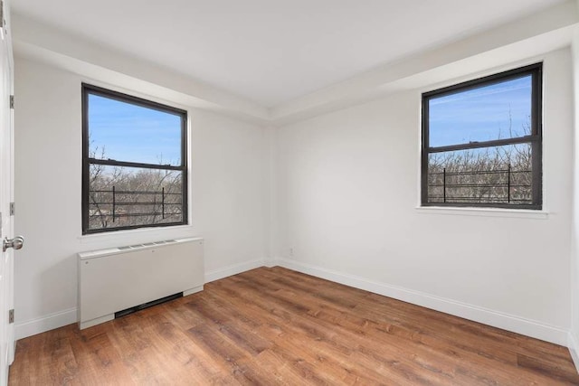 empty room with radiator and wood-type flooring