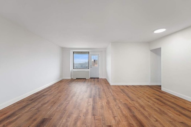 unfurnished room with dark wood-type flooring