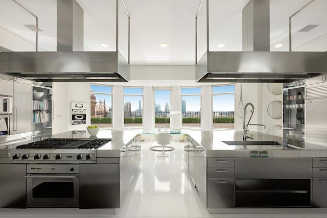 kitchen featuring stainless steel range, island range hood, sink, and tile patterned floors