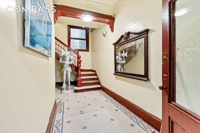 hallway with ornamental molding, baseboards, and stairs