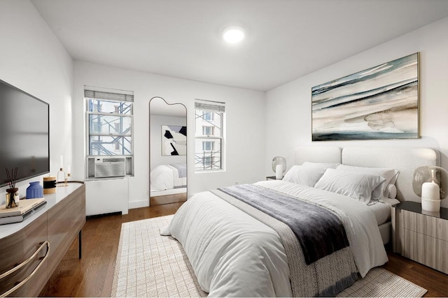 bedroom with cooling unit and dark hardwood / wood-style flooring