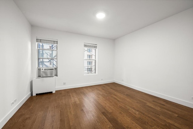 spare room featuring dark wood-type flooring, radiator, and cooling unit