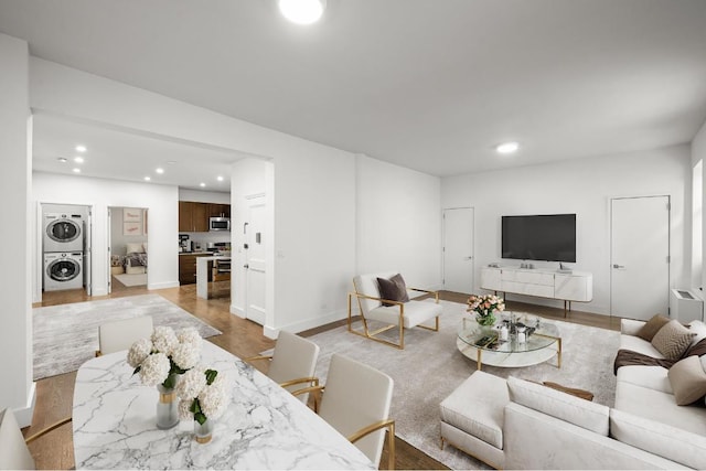 living room with stacked washer and dryer and light wood-type flooring