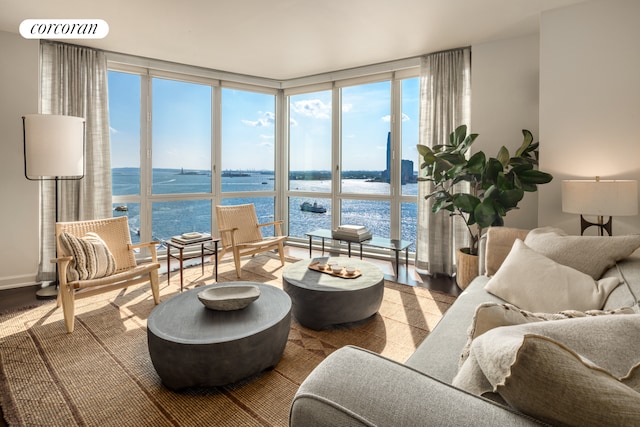 20 River Ter Unit 20D, New York City, NY 10282 - living area with expansive windows, a water view, healthy amount of natural light, and wood finished floors