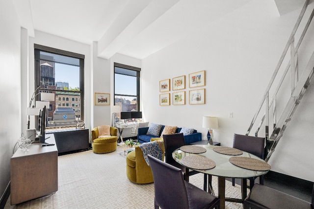 carpeted living room featuring beamed ceiling