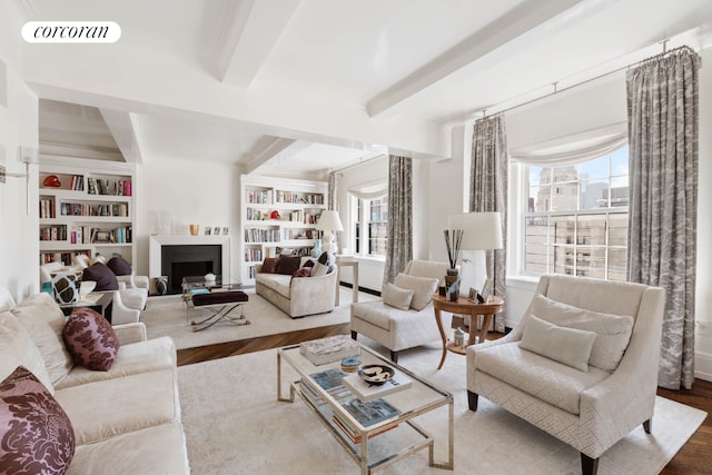 living room with beamed ceiling, built in shelves, and hardwood / wood-style floors