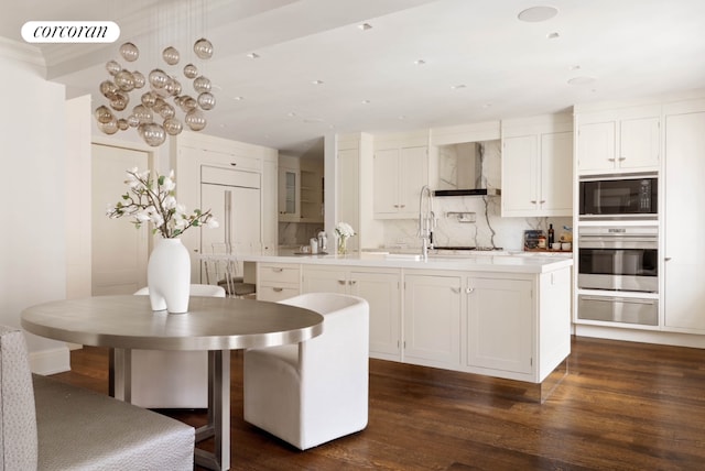 kitchen with white cabinets, an island with sink, light countertops, stainless steel oven, and a warming drawer