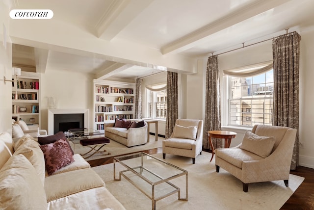 living area with a fireplace, wood finished floors, visible vents, built in features, and beam ceiling