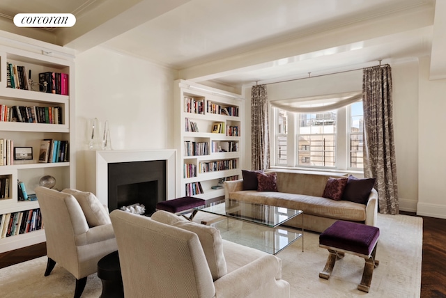 living area with a fireplace, visible vents, baseboards, built in features, and crown molding