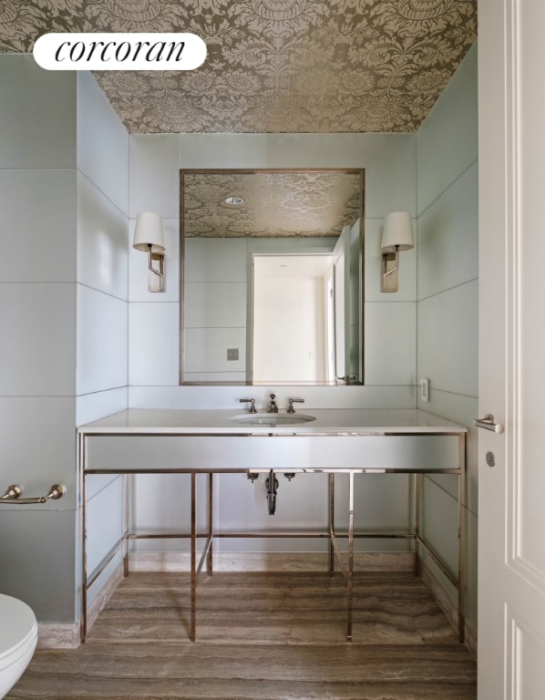 bathroom featuring toilet, an ornate ceiling, a sink, and wood finished floors