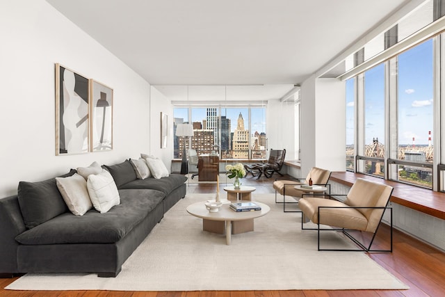 living area featuring a view of city, wood finished floors, and floor to ceiling windows