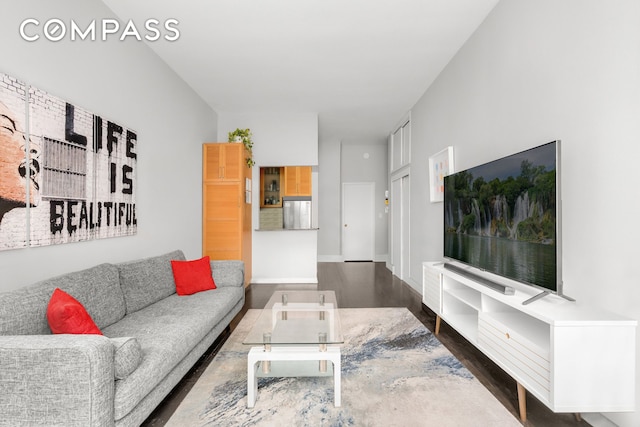 living area with dark wood-type flooring and baseboards