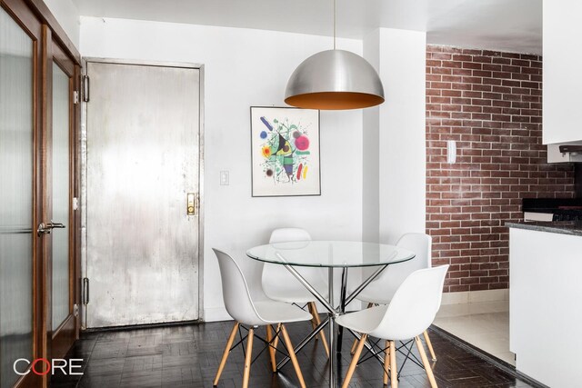 dining area featuring brick wall