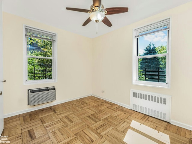 spare room featuring radiator heating unit, baseboards, ceiling fan, and a wall mounted AC