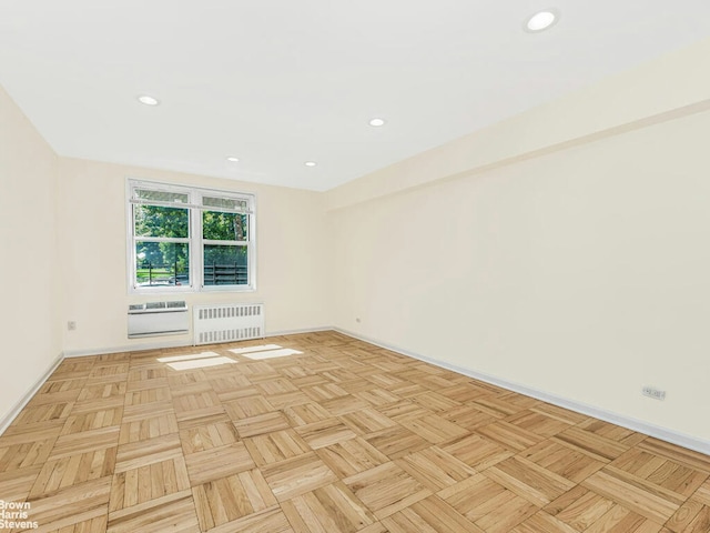 unfurnished room with baseboards, radiator heating unit, and recessed lighting