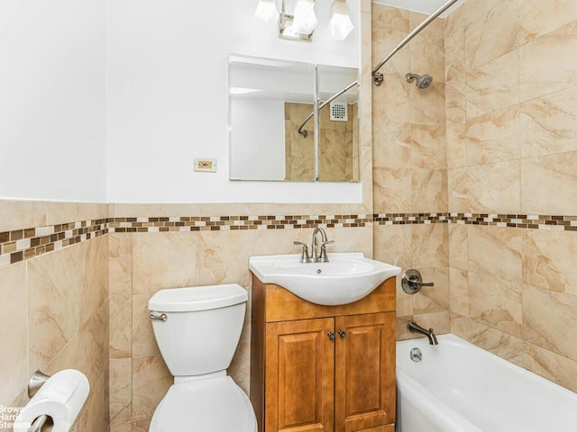 full bathroom with tile walls, shower / bathing tub combination, vanity, and toilet