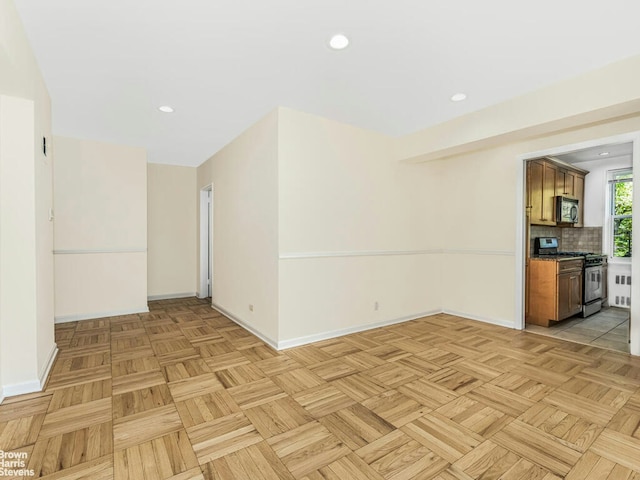 unfurnished room with baseboards and recessed lighting