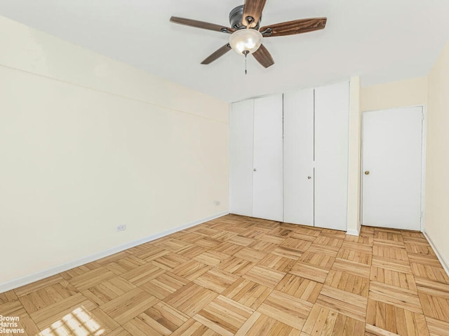 unfurnished bedroom featuring a ceiling fan, baseboards, and multiple closets