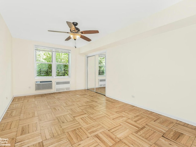 unfurnished room with a ceiling fan, radiator, and baseboards