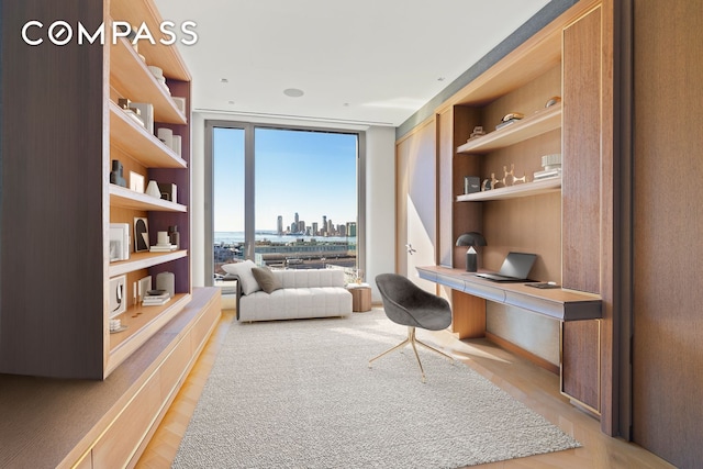 office area featuring a view of city, built in shelves, built in study area, and floor to ceiling windows