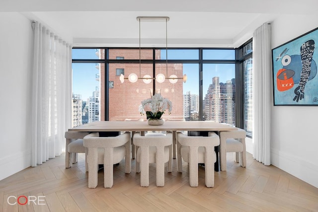 dining space with light parquet flooring, a wealth of natural light, and a notable chandelier