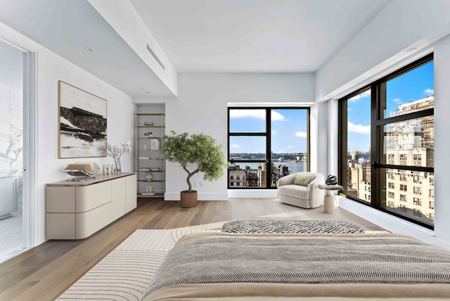 bedroom with a water view and light wood-type flooring