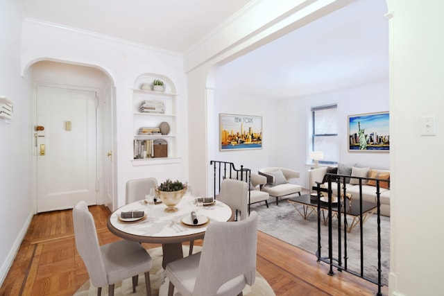 dining room with ornamental molding, hardwood / wood-style floors, and built in features