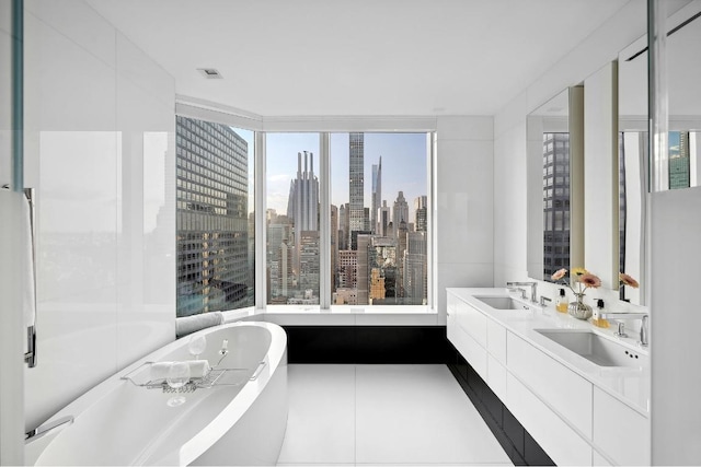 bathroom featuring tile patterned floors, vanity, and a bath